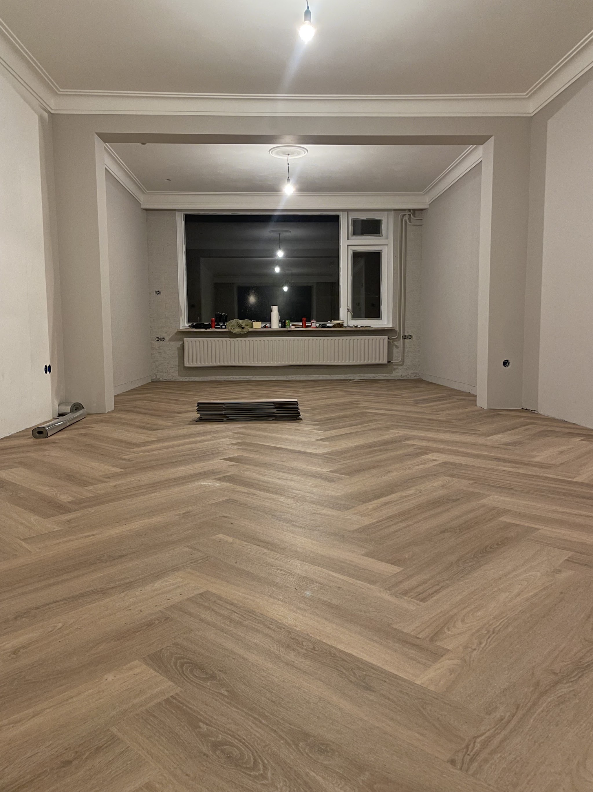 Lege woonkamer met een nieuw gelegde visgraatvloer