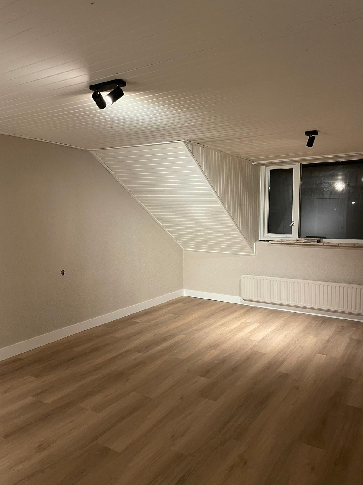 Zolderkamer met een nieuwe houten vloer