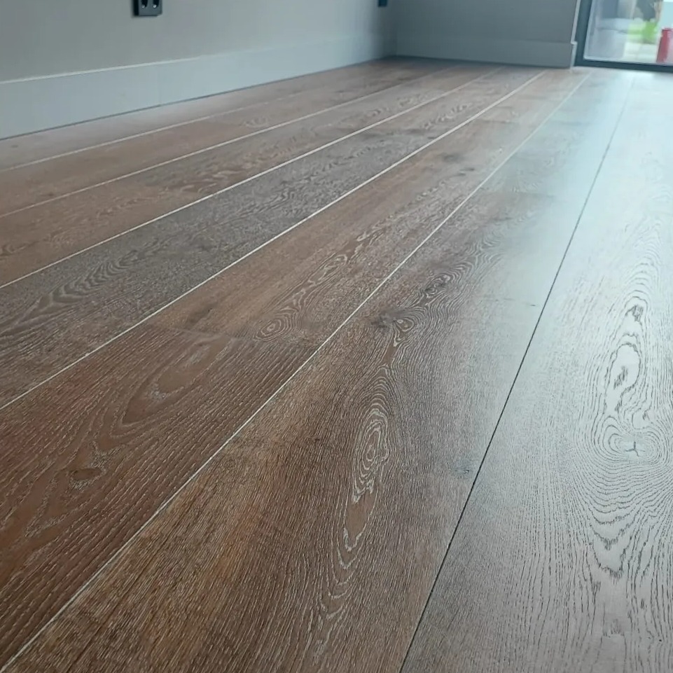 Lange eiken planken op de vloer, laag vanaf de grond gefotografeerd